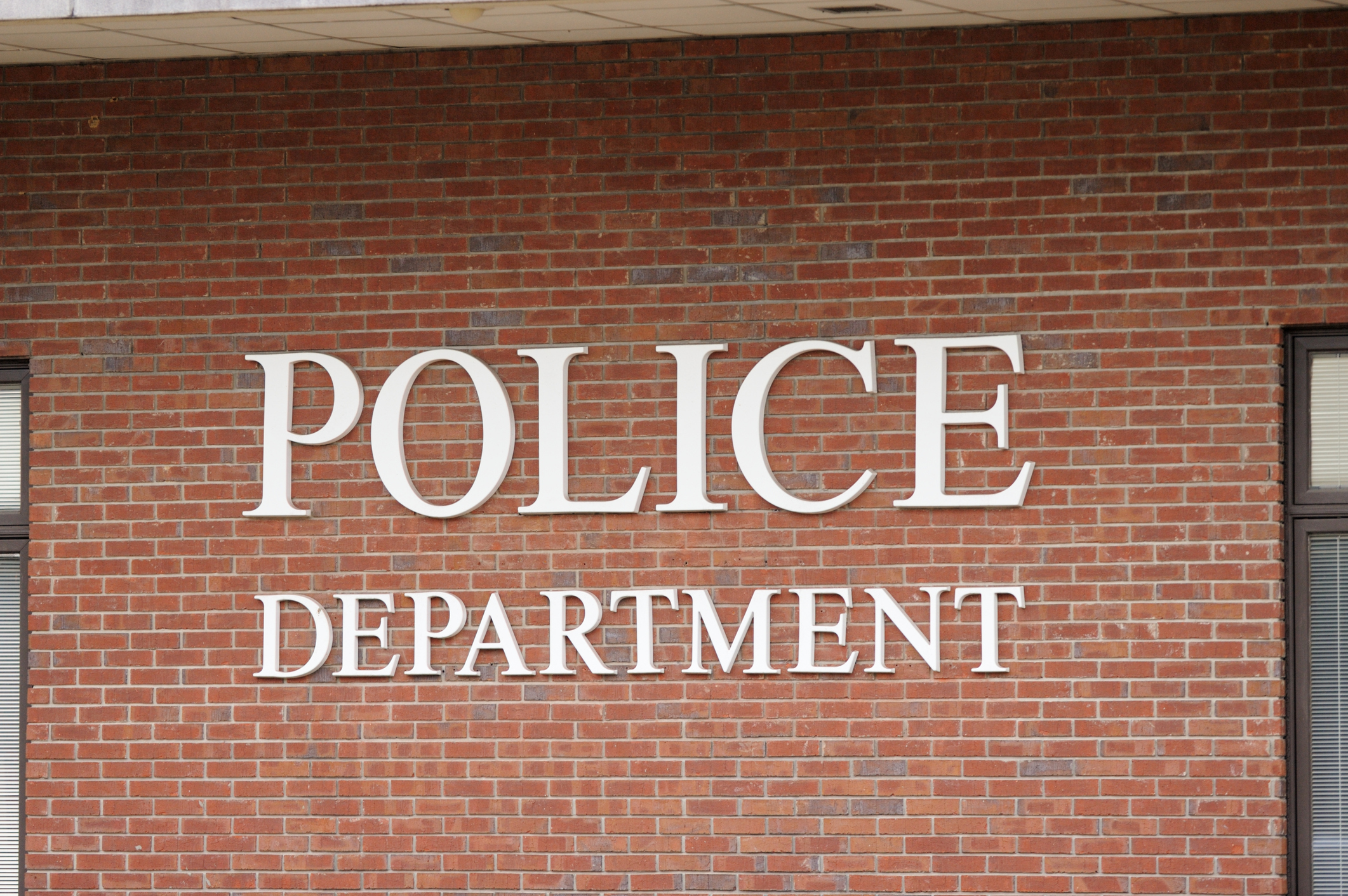 Police department sign on brick wall close up