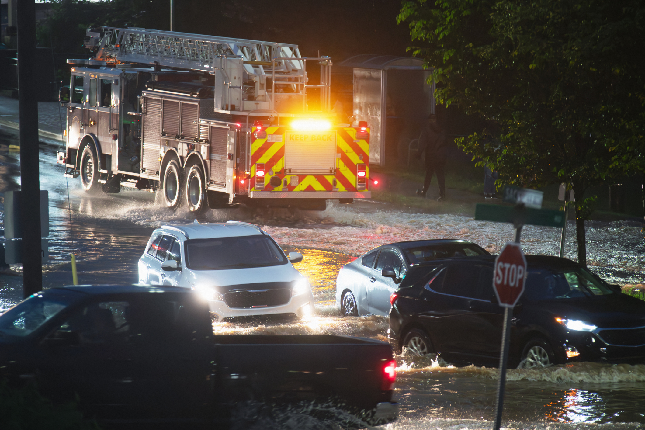 A firetruck and cars drive through flood waters after record setting rainfall.